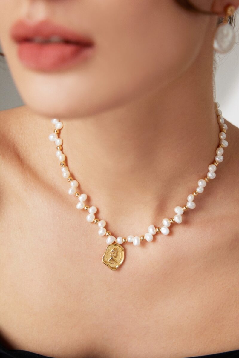 Close-up of a woman wearing a Product Name with natural pearl, focusing on the necklace and her chin. Elegant pearl jewelry