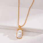 A gold necklace with a large, irregularly shaped image1 (2) pendant, displayed against a white textured background. Elegant pearl jewelry