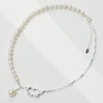 A necklace on a white background, featuring a sterling silver chain with a heart-shaped clasp and a single pearl pendant. Elegant pearl jewelry