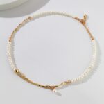 A necklace with a central gold twisted segment, featuring a gold clasp and adjustable chain, displayed against a white background with a subtle shadow. Elegant pearl jewelry