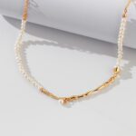 An elegant necklace with a gold chain detail, displayed on a white surface with soft shadows. Elegant pearl jewelry