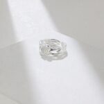 Ring with a freshwater pearl in a twisted design, resting on a white surface. Elegant pearl jewelry