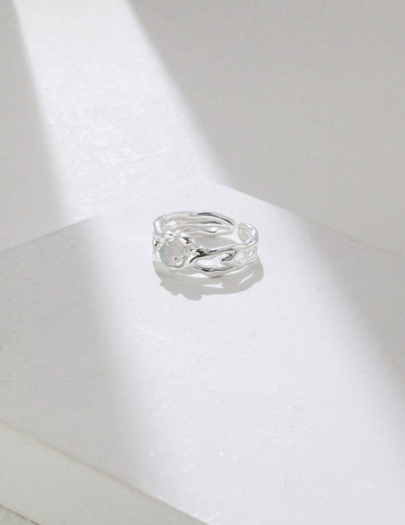 Ring with a freshwater pearl in a twisted design, resting on a white surface. Elegant pearl jewelry