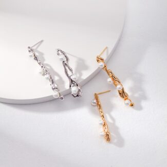 Two pairs of elegant earrings displayed on a white surface; one pair is with a twisted design and natural pearl embellishments, the other is gold with a similar twisted style and freshwater pearl accents Elegant pearl jewelry