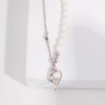 A pendant necklace with a pearl at the center, displayed against a white background. Elegant pearl jewelry