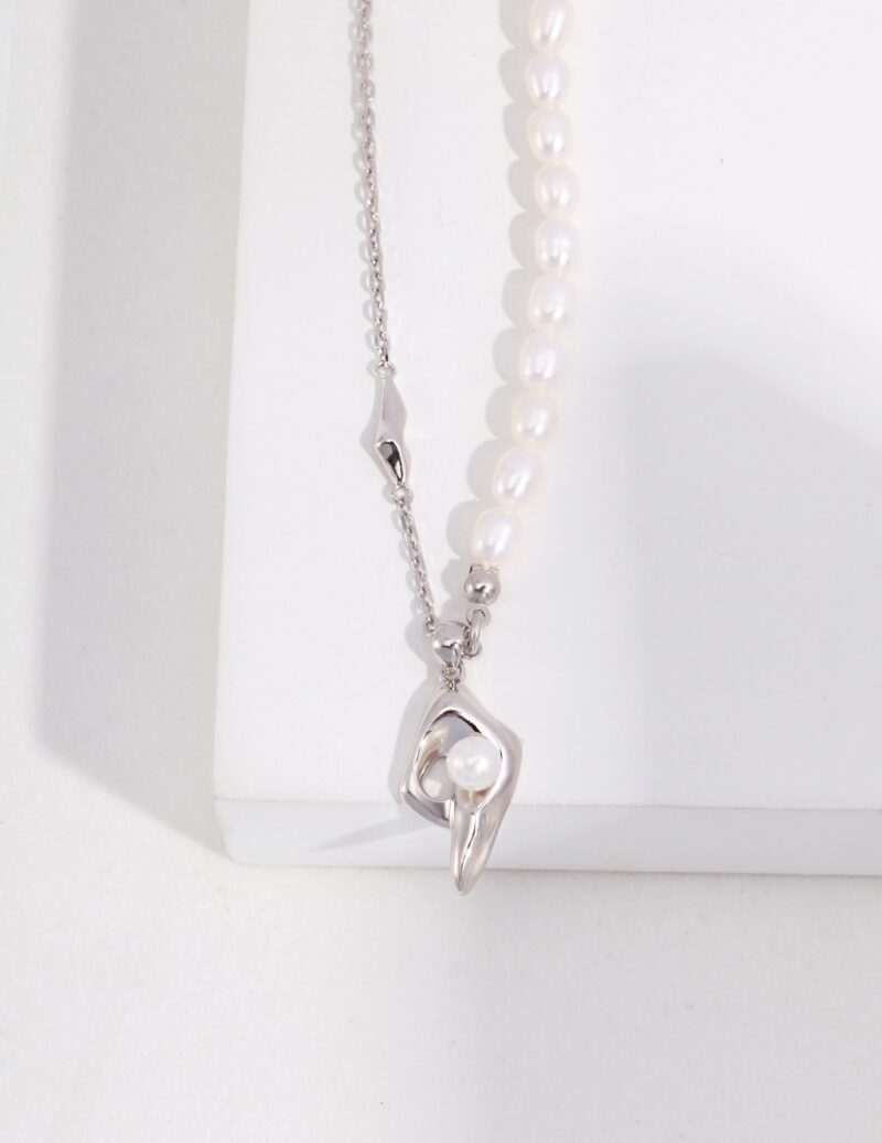 A pendant necklace with a pearl at the center, displayed against a white background. Elegant pearl jewelry