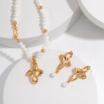 The product named o_1gh7t4hqa1d31dq31g1vkpe1nh2u is displayed on a white, circular surface, featuring a jewelry set that includes a pearl necklace with 18k Gold Vermeil accents and matching gold earrings adorned with floral designs and pearl drops. Elegant pearl jewelry