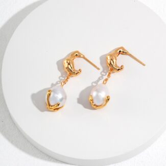 A pair of elegant  drop earrings with a swan design at the top and a dangling freshwater pearl at the bottom, displayed on a white circular surface. Elegant pearl jewelry