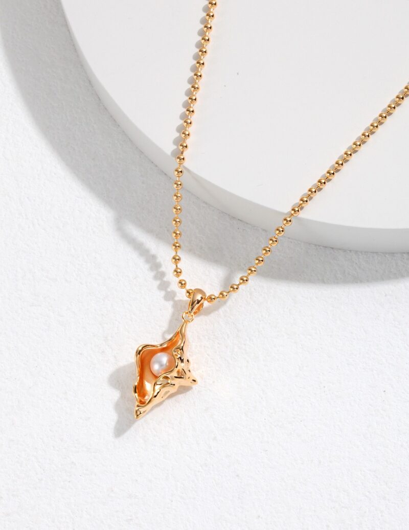 A o_1gkagg58c1ju1aojbld1k6330e2t with a pendant shaped like a leaping fox, featuring a natural pearl inset, displayed on a light, textured background. Elegant pearl jewelry