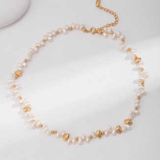 Elegant necklace with interspersed gold leaf-shaped charms, displayed on a soft white surface, lit by natural light. Elegant pearl jewelry