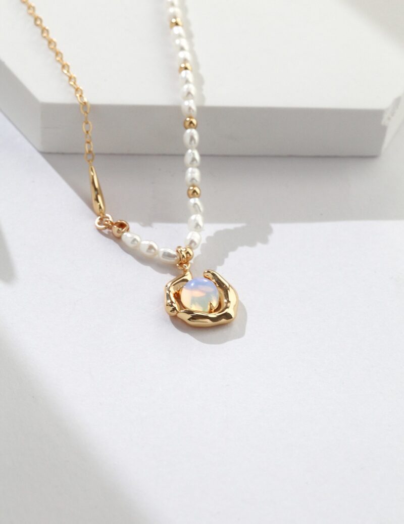 A pendant on a freshwater pearl necklace, draped atop a white background illuminated by natural sunlight. Elegant pearl jewelry