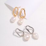 A pair of gold and silver earrings, both with irregular hoop designs and attached natural pearls, displayed on a light background. Elegant pearl jewelry