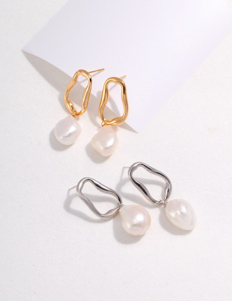 A pair of gold and silver earrings, both with irregular hoop designs and attached natural pearls, displayed on a light background. Elegant pearl jewelry