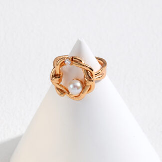 An elegant  ring with a pearl, displayed on a white cone-shaped stand against a light gray background. Elegant pearl jewelry