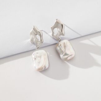 A pair of elegant pearl earrings with abstract sterling silver tops and iridescent square freshwater pearl drops, showcased against a clean white background. Elegant pearl jewelry