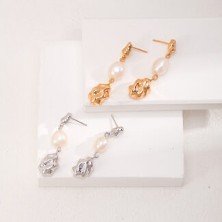 A collection of earrings displayed on a white stepped platform, featuring designs with gold pearl jewelry and sterling pearl jewelry accents. Elegant pearl jewelry