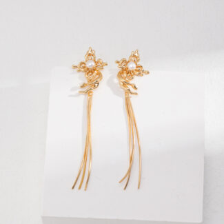 A pair of intricate  tassel earrings displayed on a plain white stand against a light gray background. The earrings have a detailed floral design at the top featuring natural pearl. Elegant pearl jewelry