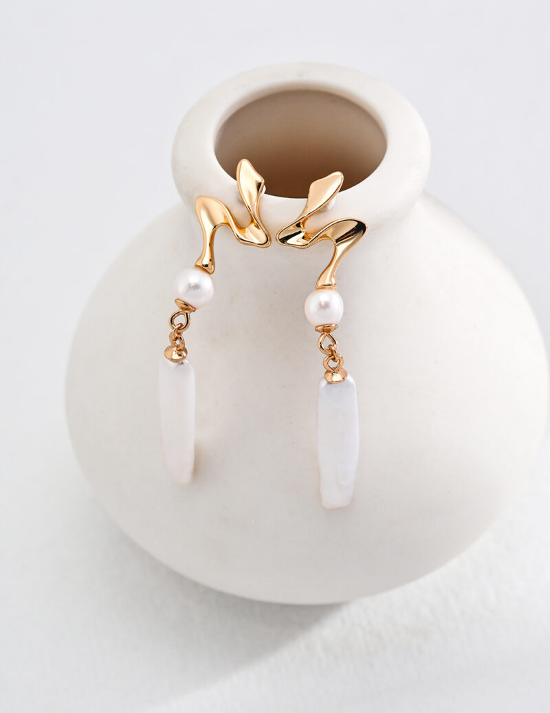 Elegant gold pearl jewelry earrings with a swan design, featuring freshwater pearls and white drop pendants.