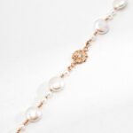 A delicate bracelet featuring a string of alternating large and small pearls with a gold vermeil sunburst charm centered on a plain white background. Elegant pearl jewelry